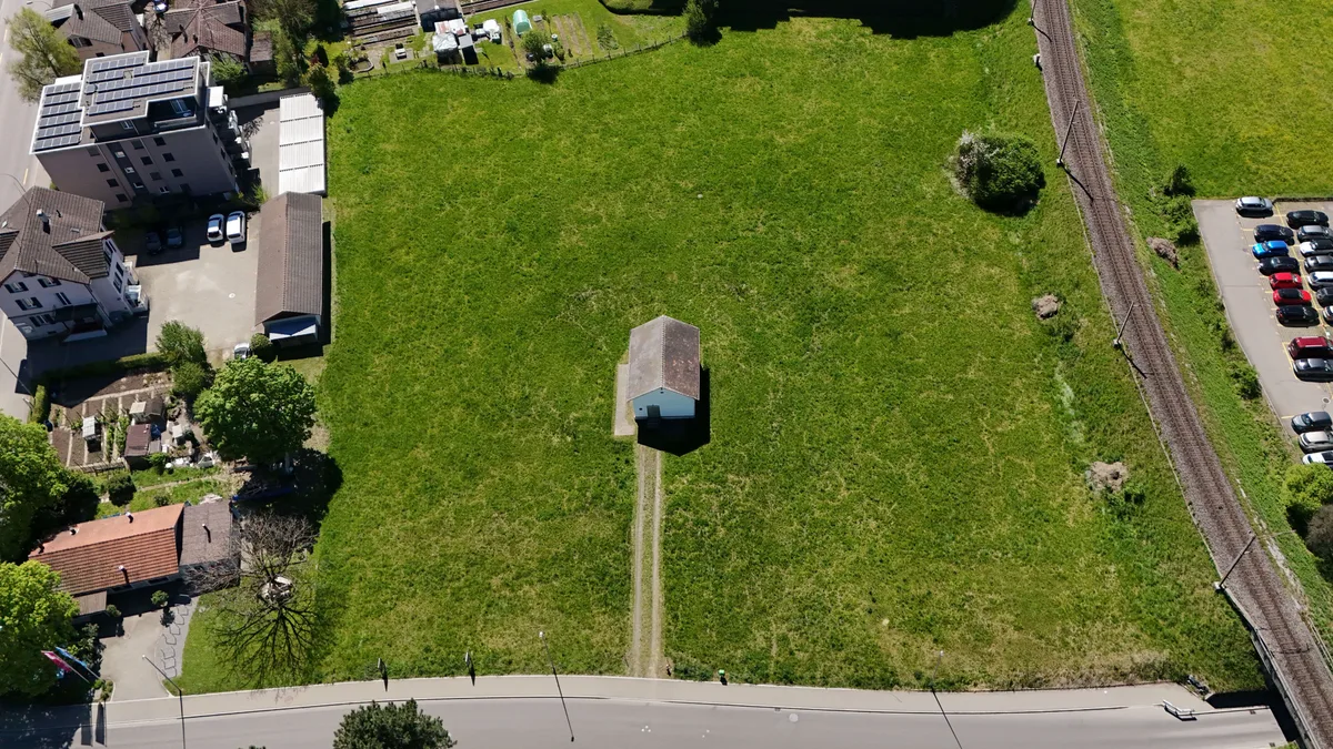 Heute steht das Häuschen der Grundwasserfassung auf der grünen Wiese. Doch es ist möglich, darauf einen Park zu erstellen. Tinkwasserfassung Feld, weisses Häuschen steht auf einer grünen Wiese